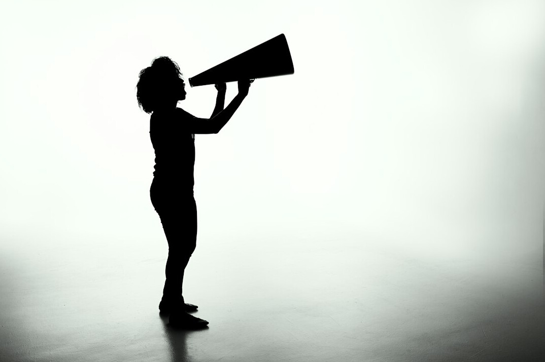 Silhouette of a speaker in motion on stage with backlight