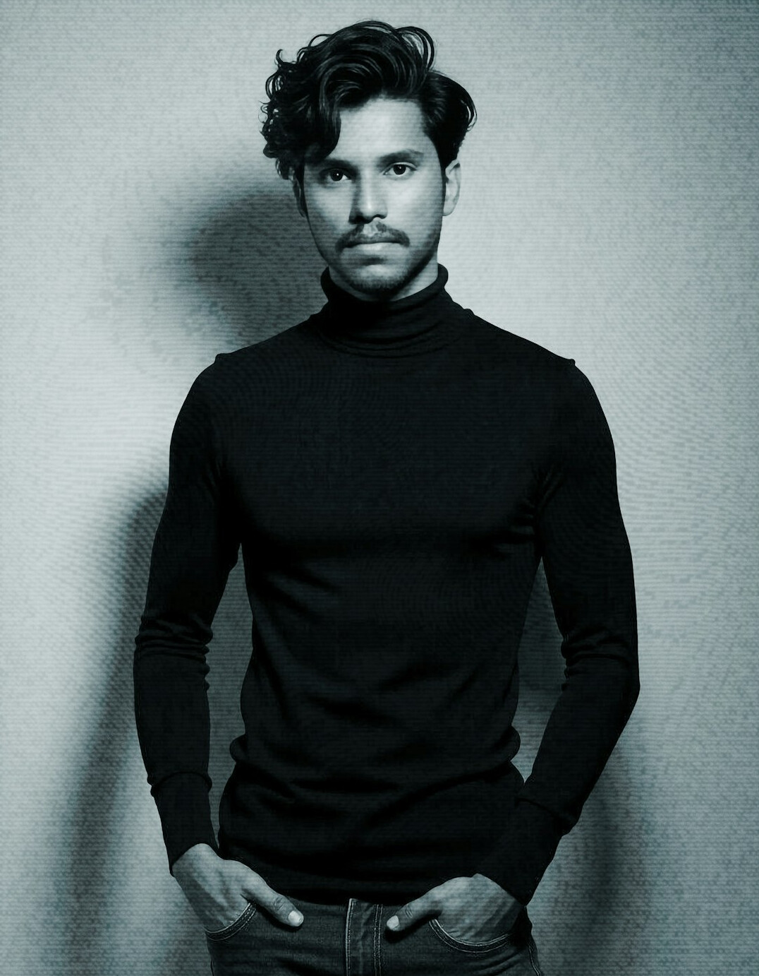 Portrait of a man with a trimmed beard in a charcoal turtleneck